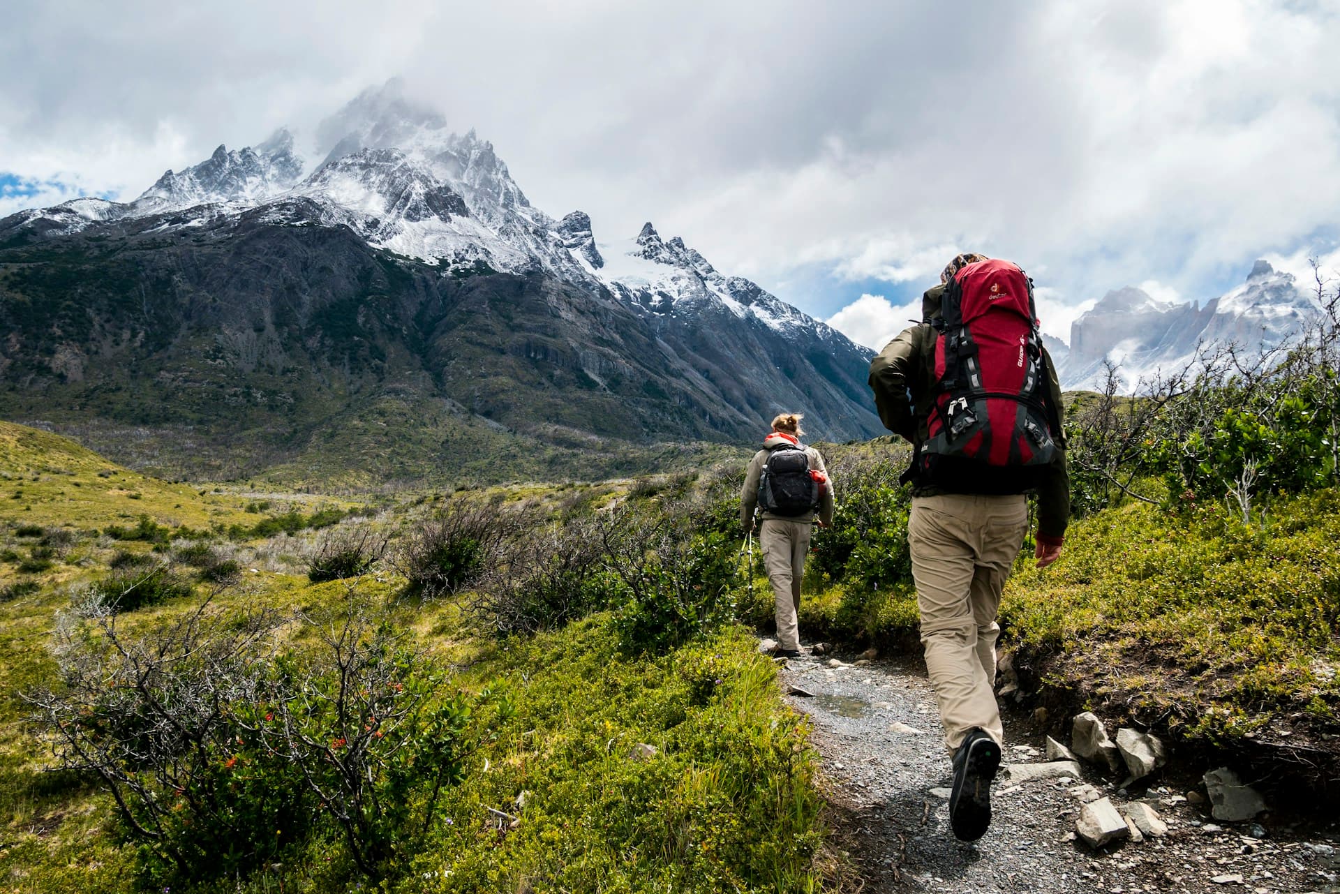 Hiker on a dramatic mountain trail with sweeping valley views