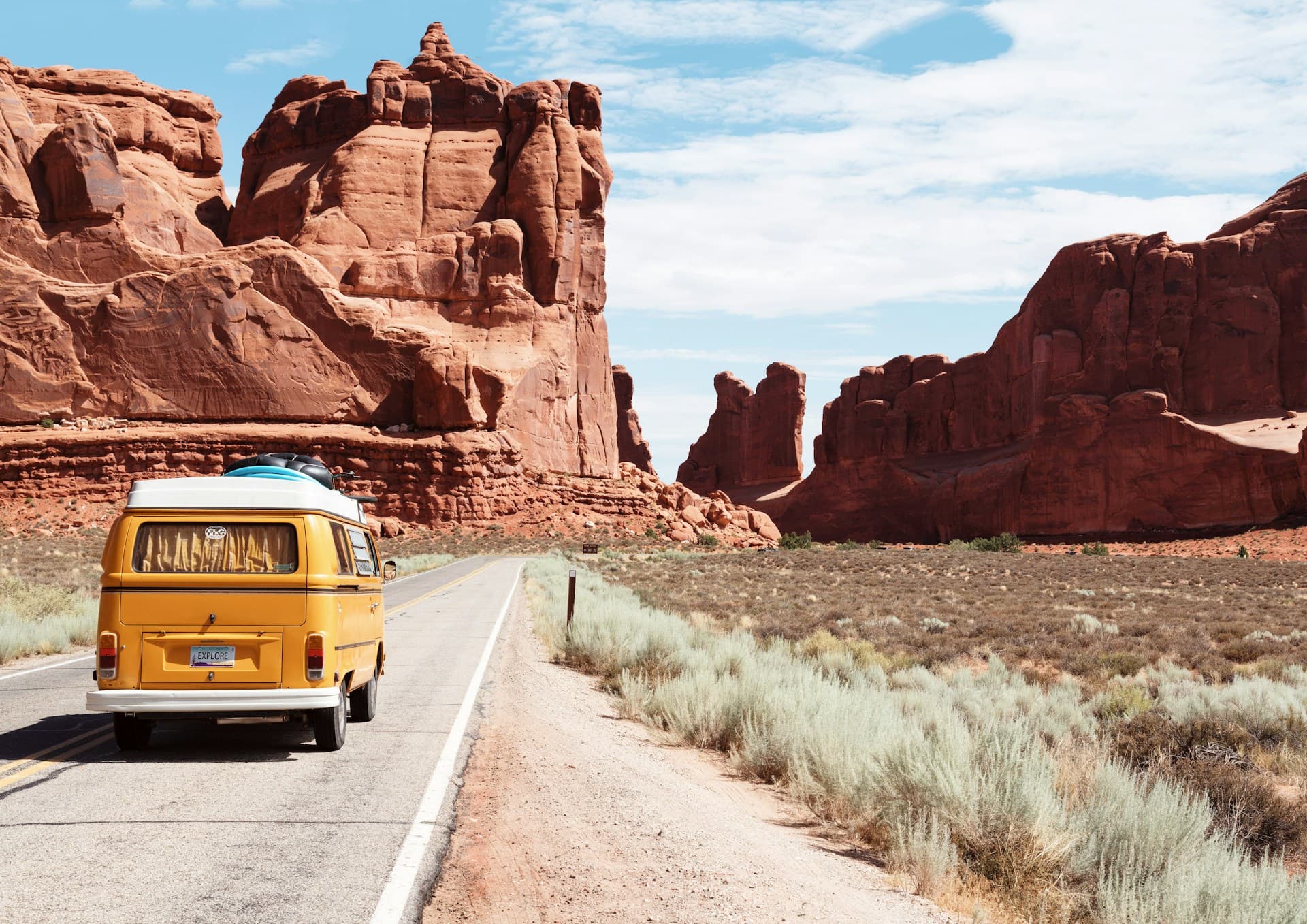 Empty highway stretching through red desert rock formations
