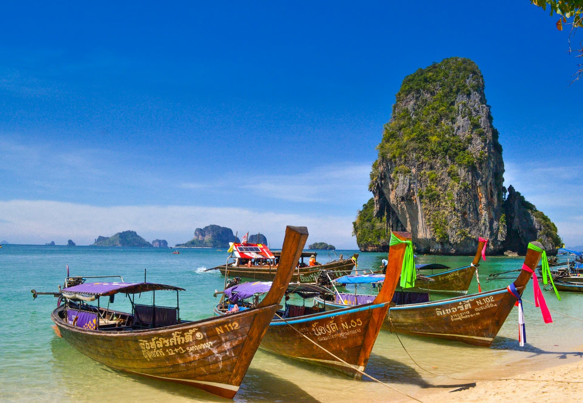 Golden Buddhist temple spires against a blue sky in Thailand