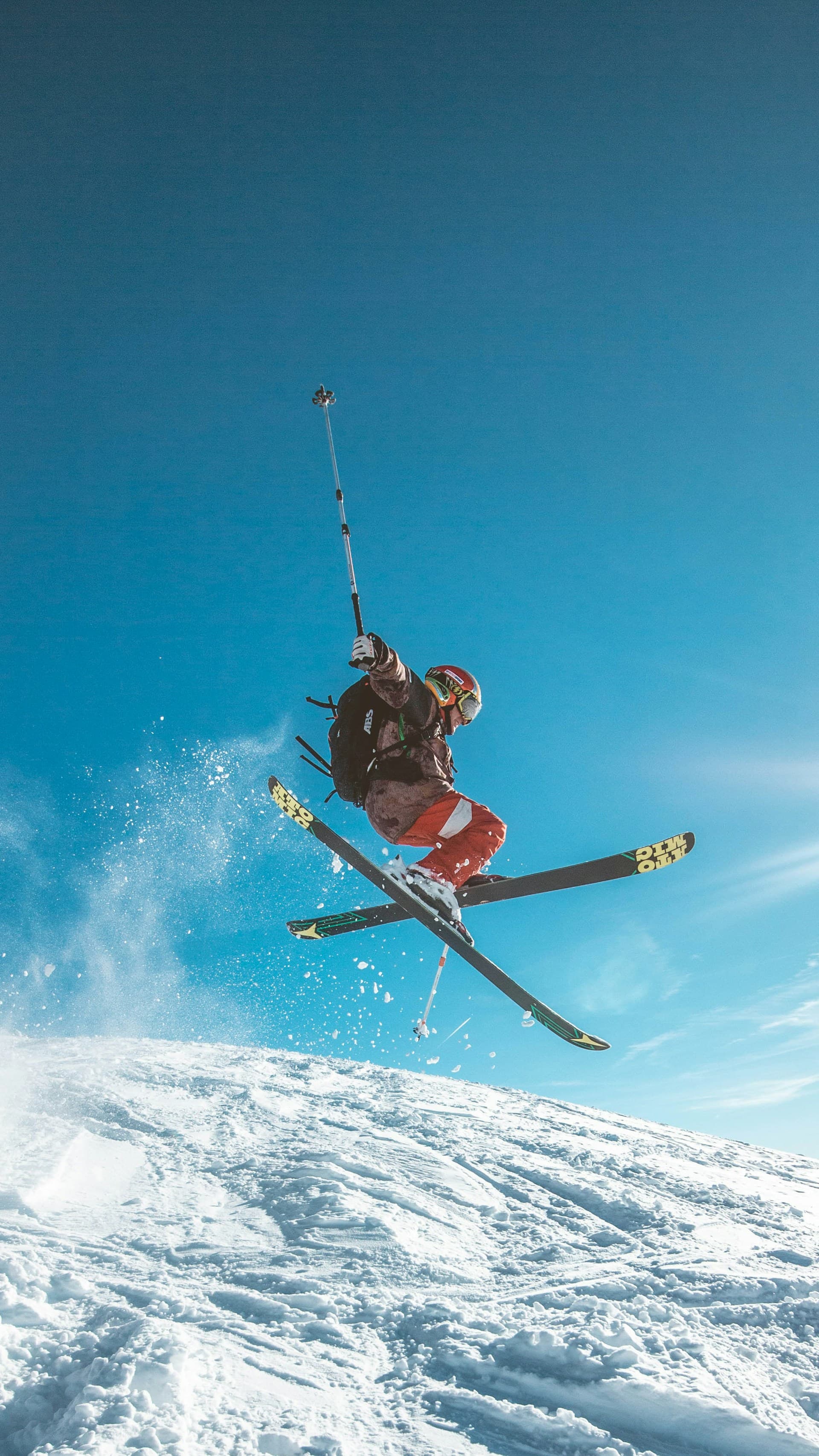 Group of friends posing with skis on a sunny mountain slope