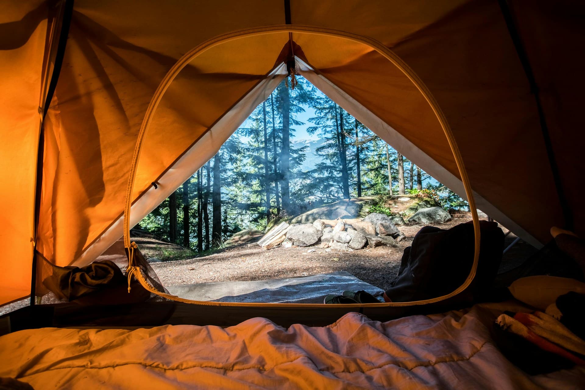 Campfire on a cliff overlooking a breathtaking mountain valley at golden hour