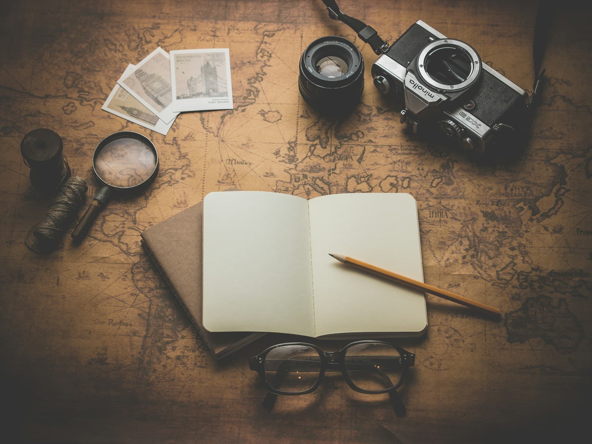 Flat lay of travel planning essentials including map, camera, and passport